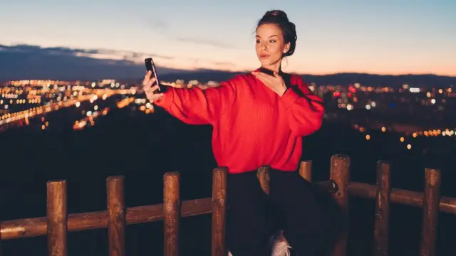 Mulher jovem fazendo selfie com celular