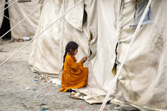 An Afghan child who fled due to the fighting between Taliban and Afghan security forces from northern provinces plays near her temporary shelter in a public park in Kabul, Afghanistan, 14 August (issued 15 August).