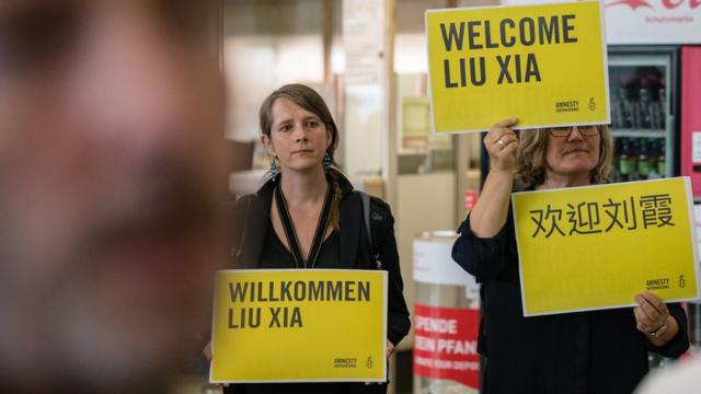 刘霞到达德国柏林时，有民间组织人士到机场举起标语欢迎。
