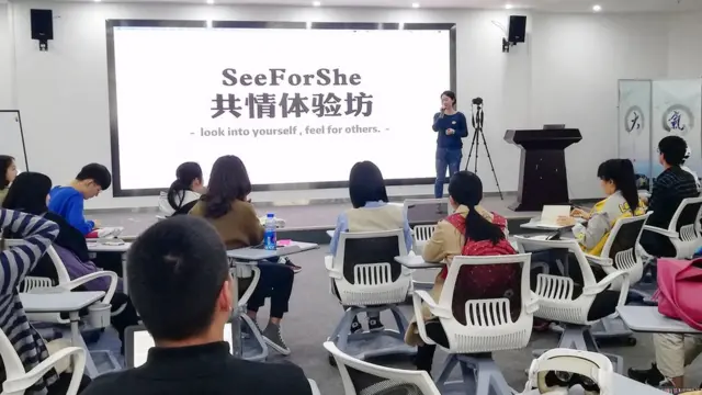 Students listen to Lisa in a workshop setting.