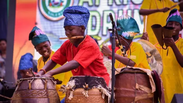 Ọmọde kan ati awọn akẹgbẹ n lu ilu