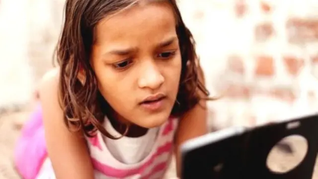 मोबाइल देखती एक बच्ची