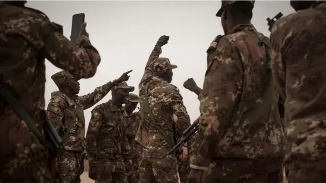 Des soldats maliens dansent après la cérémonie de remise de la base militaire de Barkhane par l'armée française à Tombouctou, le 14 décembre 2021.