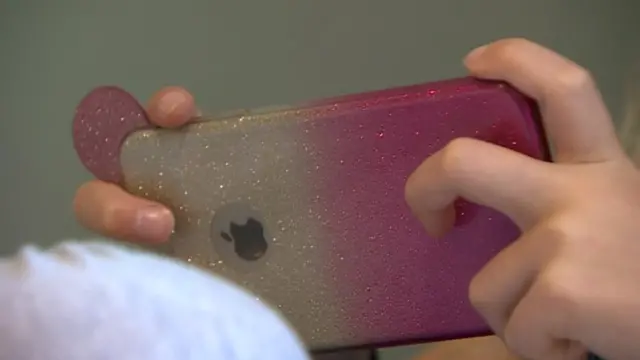 فتاة تستخدم هاتفا محمولا