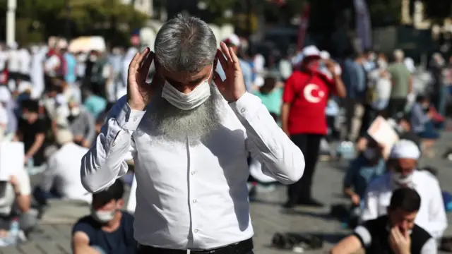 People wait for the first Friday prayer during the official opening ceremony of Hagia Sophia as a mosque in Istanbul