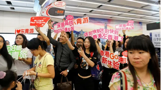 Tour guides greet passengers from China at West Kowloon Terminus at the first day of service of the Hong Kong Section of the Guangzhou-Shenzhen-Hong Kong Express Rail Link, in Hong Kong, China September 23, 2018. REUTERS/Tyrone Siu