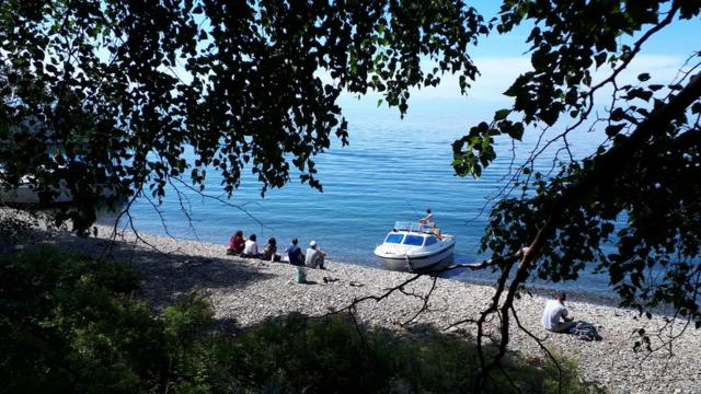 游客坐在贝加尔湖畔眺望景色
