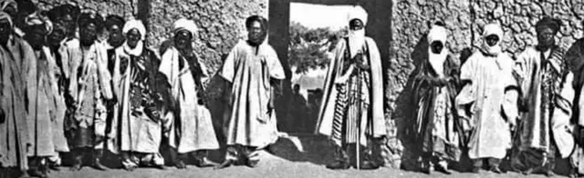 Sarkin Kano Abbas tare da hakimansa a bakin daya daga kofofin Kano jim kadan bayan turawa sun nada shi sarki na farko a zamaninsu
