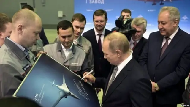 रशियाचे अध्यक्ष व्लादिमीर पुतिन स्वाक्षरी करताना