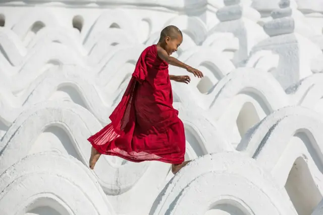 A Novice Monk has a bit of fun at the Hsinbyume Pagoda in Mandalay, Myanmar