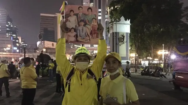 หญิงชายคู่นี้มาร่วมชุมนุมพร้อมกับพระบรมฉายาลักษณ์ครอบครัว "มหิดล"