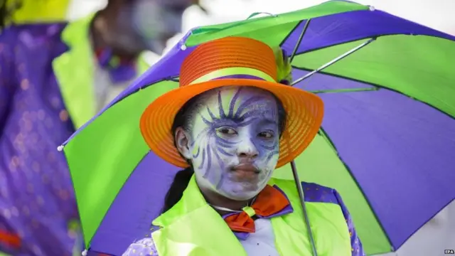 केपटाउन में नए साल के जश्न में छतरी लिए परेड में एक बच्ची