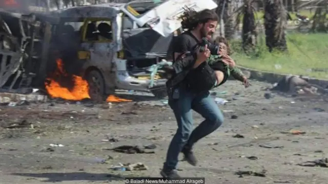 Syrian photographer Abd Alkader Habak carried a child to safety after a convoy of buses carrying evacuees from Syrian villages was bombed