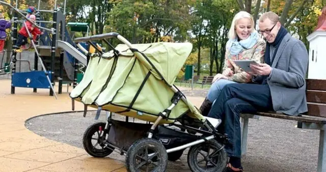 pareja con tableta y carritos de bebé