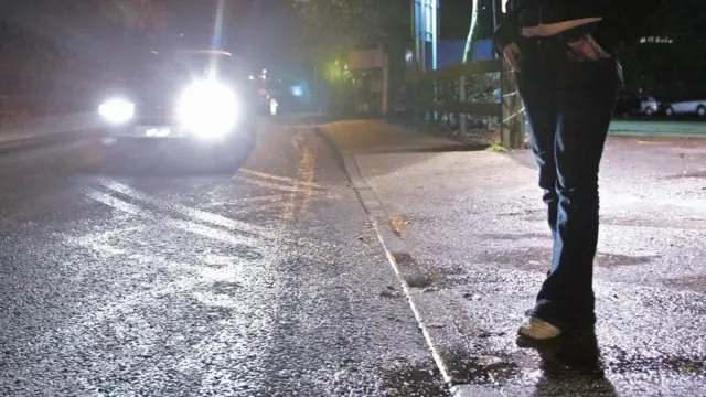 ผู้หญิงยืนริมถนน