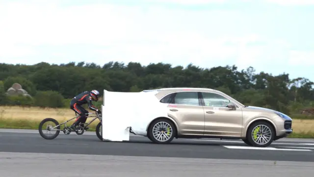 Neil Campbell siendo arrastrado por un Porsche Cayenne