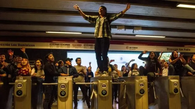 Manifestantes sobre los torniquetes del metro de Santiago de Chile