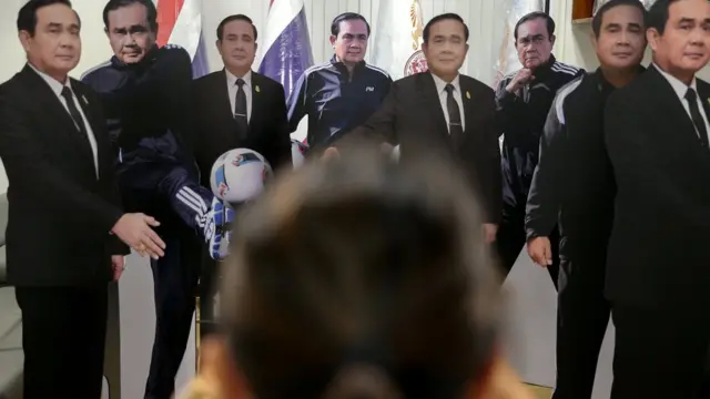 A journalist takes a photo of cardboard cut-outs of Thailand"s Prime Minister Prayuth Chan-ocha at Government House in Bangkok, Thailand, January 9,
