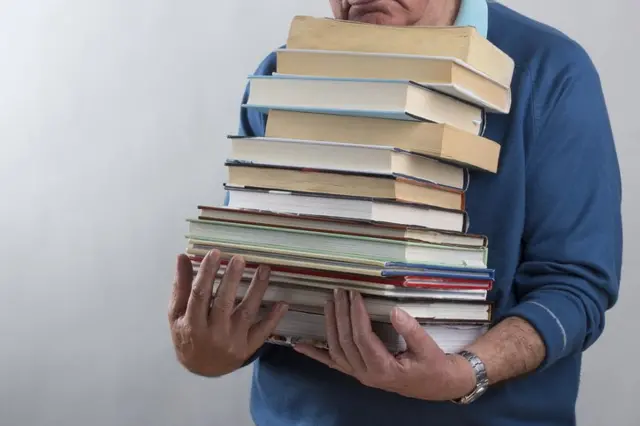 رجل يحمل كتبا