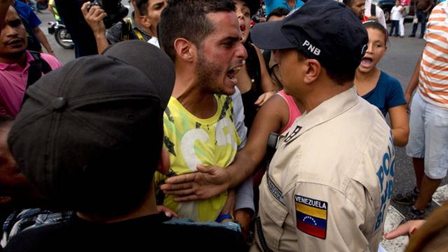 Manifestante le grita a un policía venezolano.