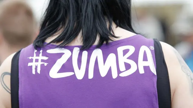 Una mujer lleva una camiseta con el nombre Zumba.
