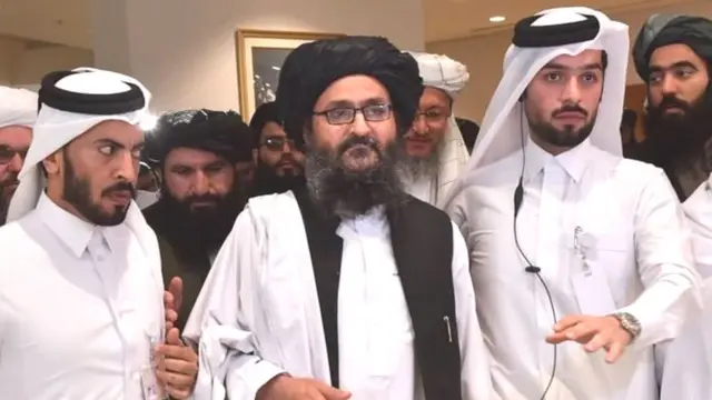 तालिबान के राजनीतिक प्रमुख मुल्ला अब्दुल ग़नी बरादर (बीच में) ने समझौते पर हस्ताक्षर किए