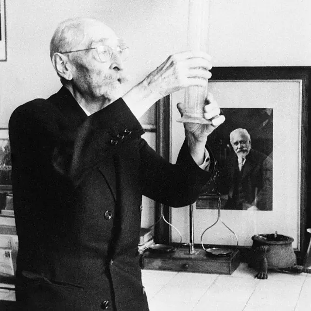 Le vétérinaire Camille Guérin. À l'arrière-plan, on peut voir un portrait de Calmette dans son laboratoire.