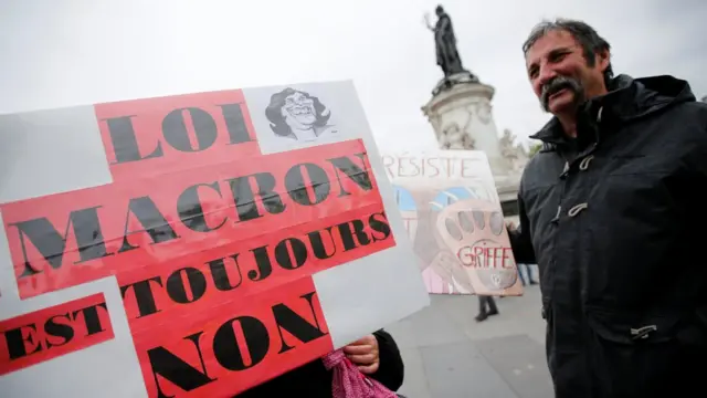 Macron Yasası'na Hayır yazılı pankart açan protestocu