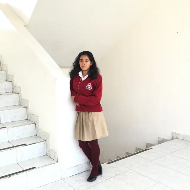 Madre adolescente de 15 años, de Quito, Ecuador, vestida con un uniforme escolar.
