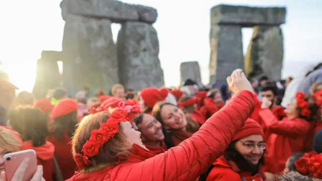 People take selfie photographs as druids, pagans and revellers gather at Stonehenge, hoping to see the sun rise, as they take part in a winter solstice ceremony at the ancient neolithic monument of Stonehenge near Amesbury on December 22, 2018