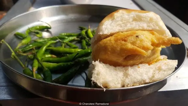 Vada pav là viên khoai tây chiên được kèm bánh mì mềm với ớt xanh cay.