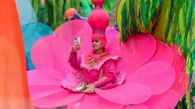 Участник парада в ярко-малиновом костюме