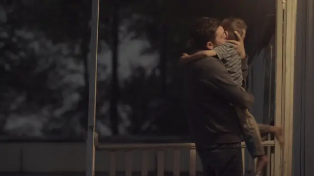 Una escena en la que uno de los migrantes abraza a su hijo.