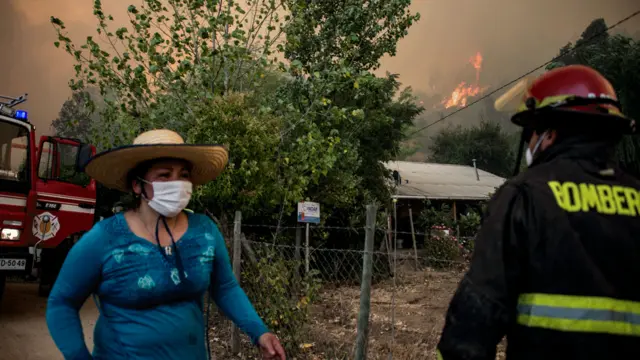 Mujer con máscara corre hacia un bombero