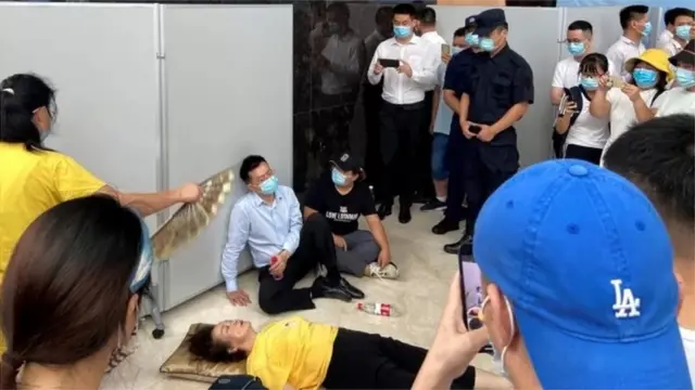 2021年9月,恆大總部門前,一位高管癱坐門前,面對抗議者此起彼伏的「還錢」呼聲——成為這個中國最大房企陷入危機的經典一幕。