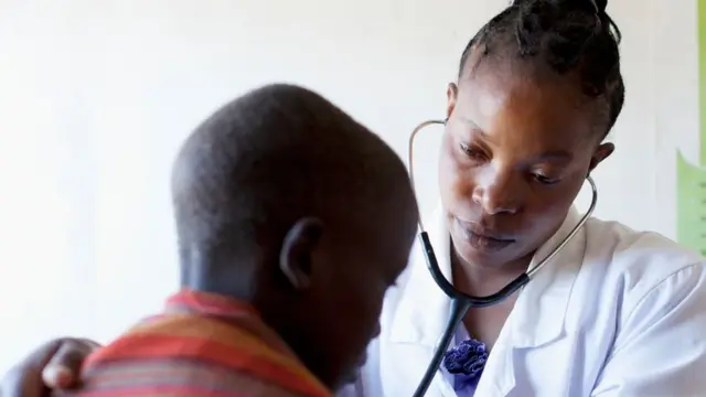 Dokter perempuan memeriksa seorang anak laki-laki