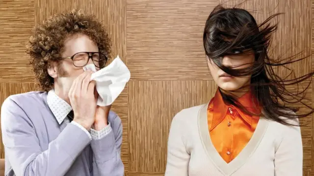 Una persona estornudando muy cerca de otra