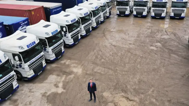 أندي سكوت يقف وسط شاحانات