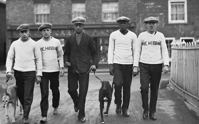 Johnson, centre, pictured with his father and manager Bill (second from right) in Manchester, December 1926
