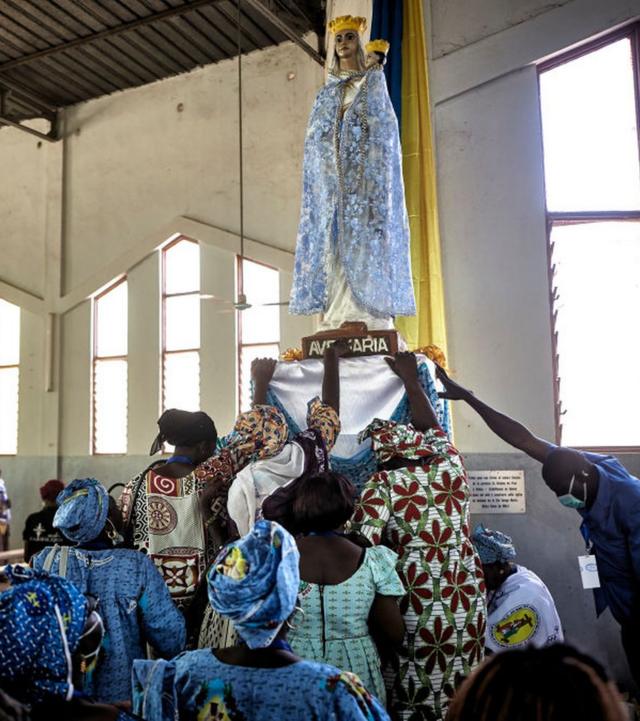 مسيحيون كاثوليك يؤدون الصلاة أمام تمثال للسيدة العذراء في مزار مقدس في مدينة كيتا بمالي