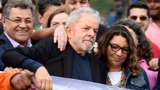 Lula prestes a entrar no carro, com uma multidão7games siga app apkvolta e ao lado da namorada Rosangela da Silva