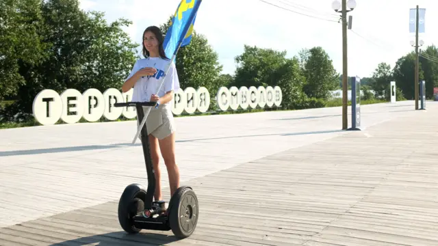 Девушка из ЛДПР катается на сегвее для съемок телевидения