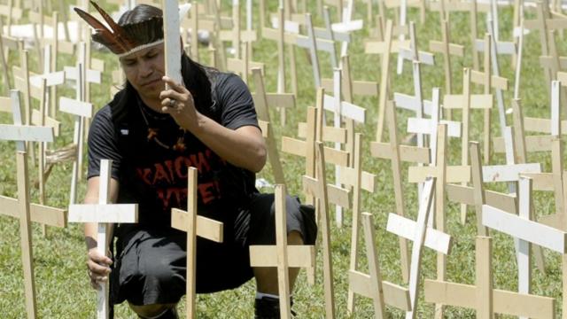 O indígena Eliseu Lopes Guarani-Kaiowá protesta em Brasília em 2012, colcoando cruzes de madeira no gramado