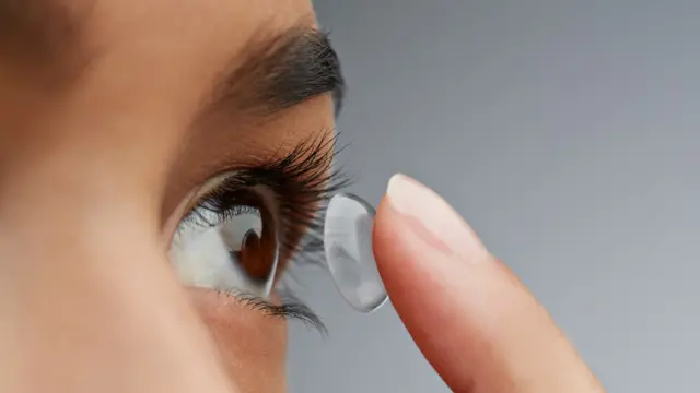 Femme insérant une lentille de contact