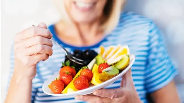 Mulher comendo frutas