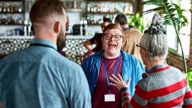 Des groupes de personnes, discutant dans un bar, et apparemment heureuses de partager des moments ensemble.