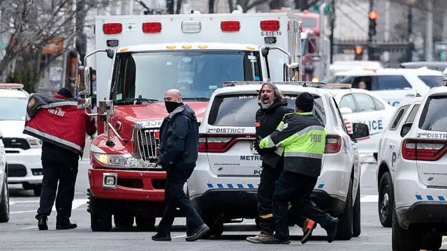 Manuel Oliver es escoltado por la policía mientras grita algo en protesta. Washington, febrero 14, 2022.