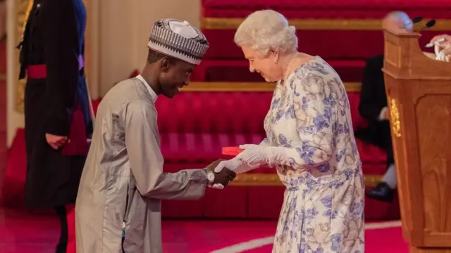 Imrana Alhaji Buba lokacin da yake karban lambar girmamawa daga sarauniyar Ingila Elizabeth II a shelara ta 2016