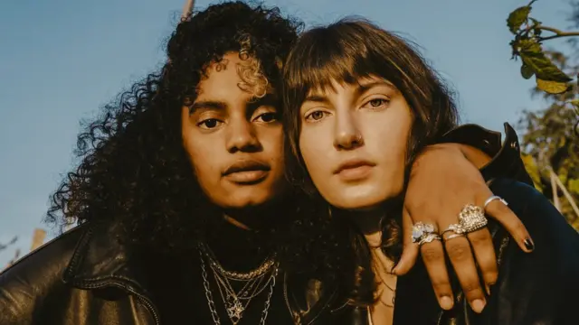 Dos jóvenes abrazadas posando frente a la cámara.