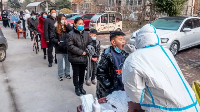 Personas en fila para hacerle la prueba de PCR en China.